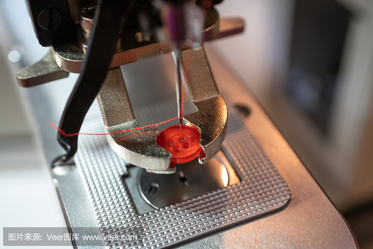 擰緊縫紉機(jī)的特寫鏡頭?，F(xiàn)代紡織工業(yè)。